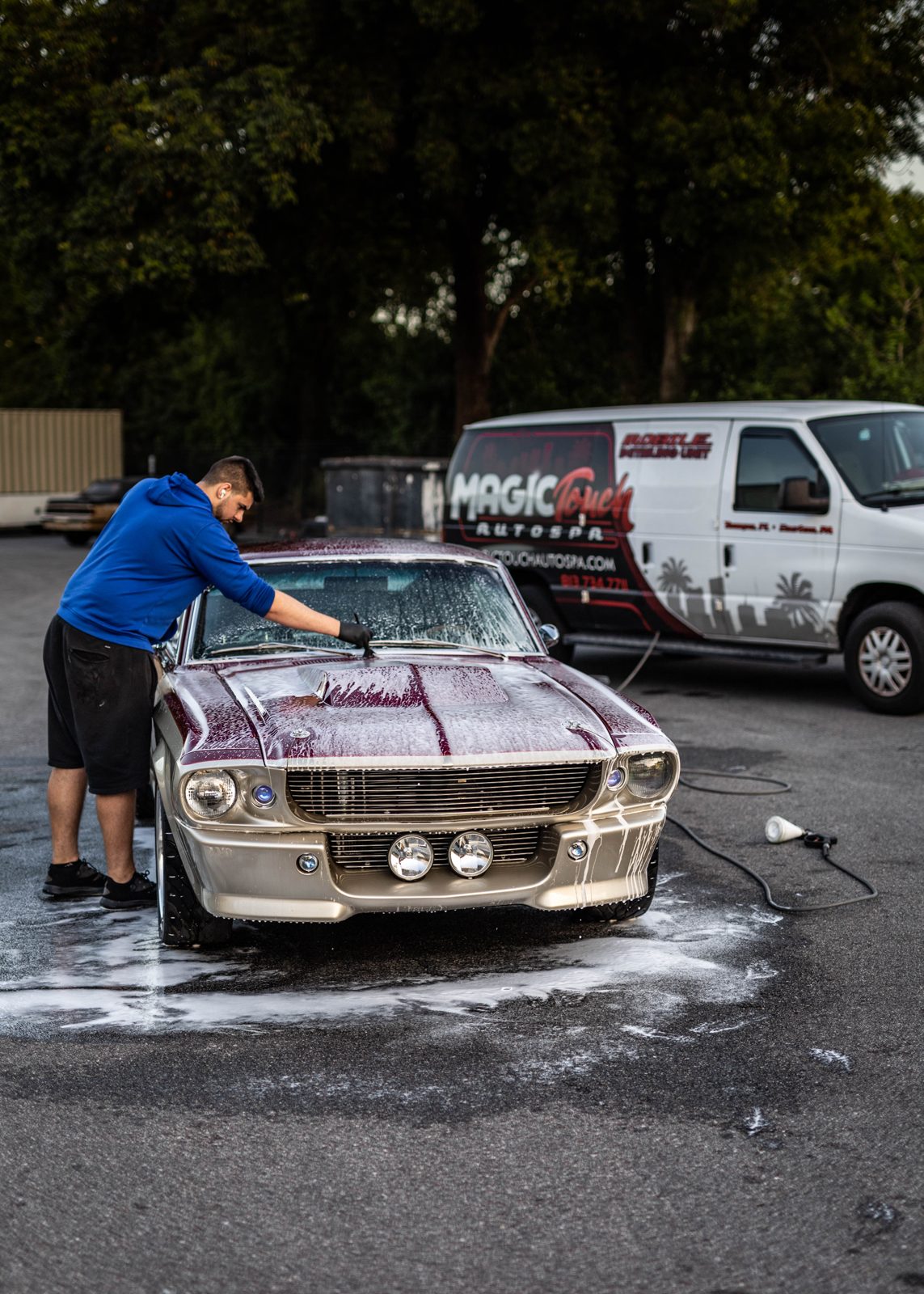 Detailer foam-washing a hull slip-side at a Falls Lake marina