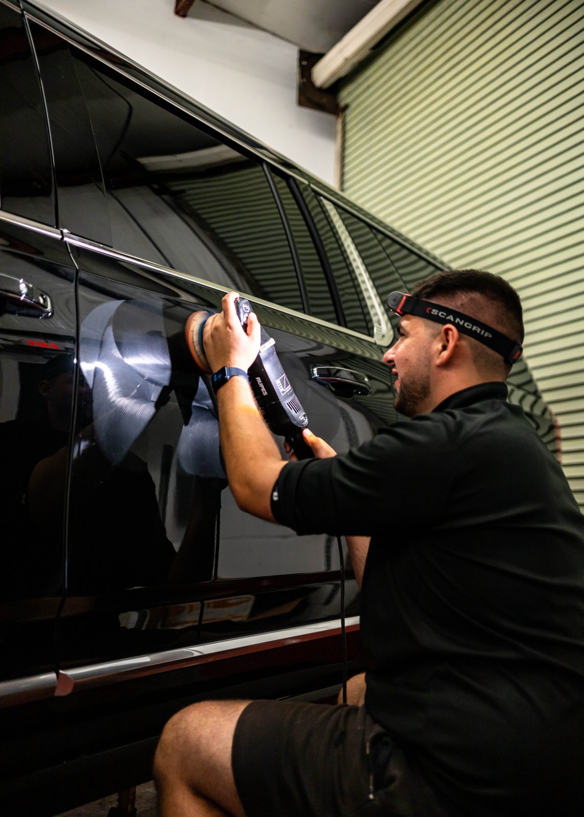 Obsidian detailer working a black car window during a Chapel Hill detail
