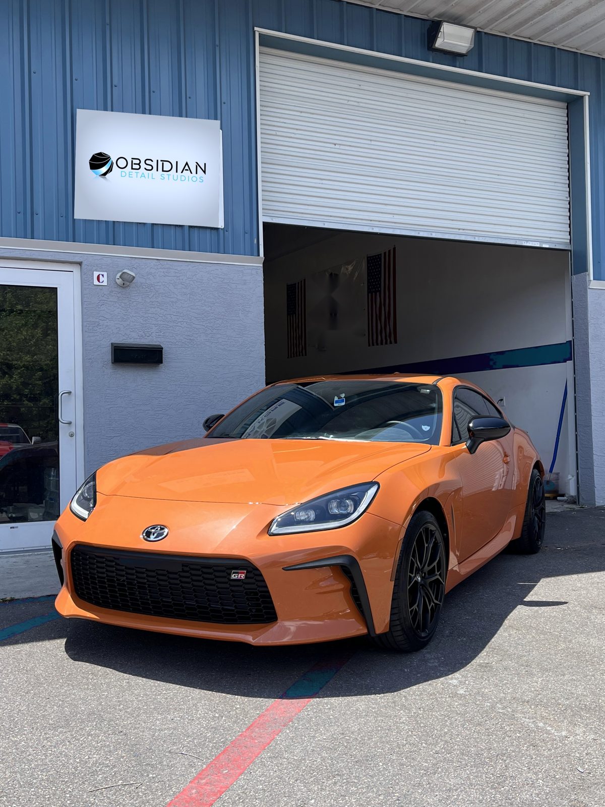 Obsidian Detail Studios rig detailing an orange GR86 on-site in Durham