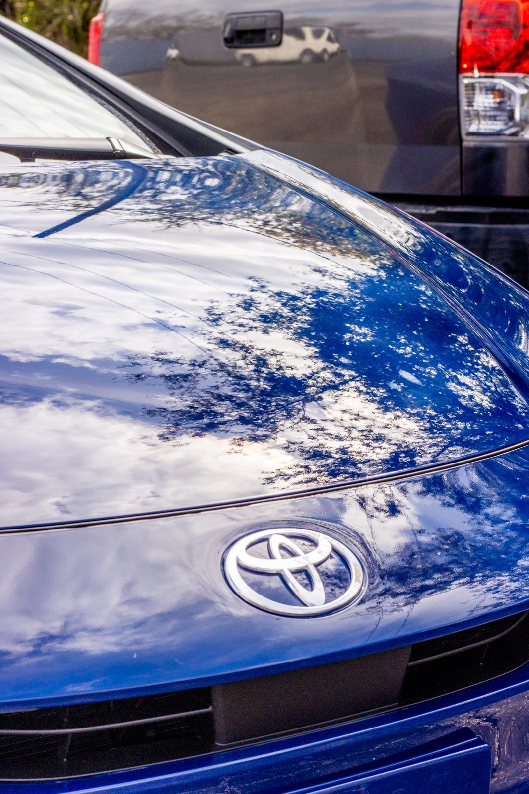 Glossy blue Toyota hood reflecting the sky after a ceramic detail in Durham, NC